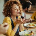 Young,Woman,With,Eyes,Closed,Enjoying,In,Taste,Of,Food